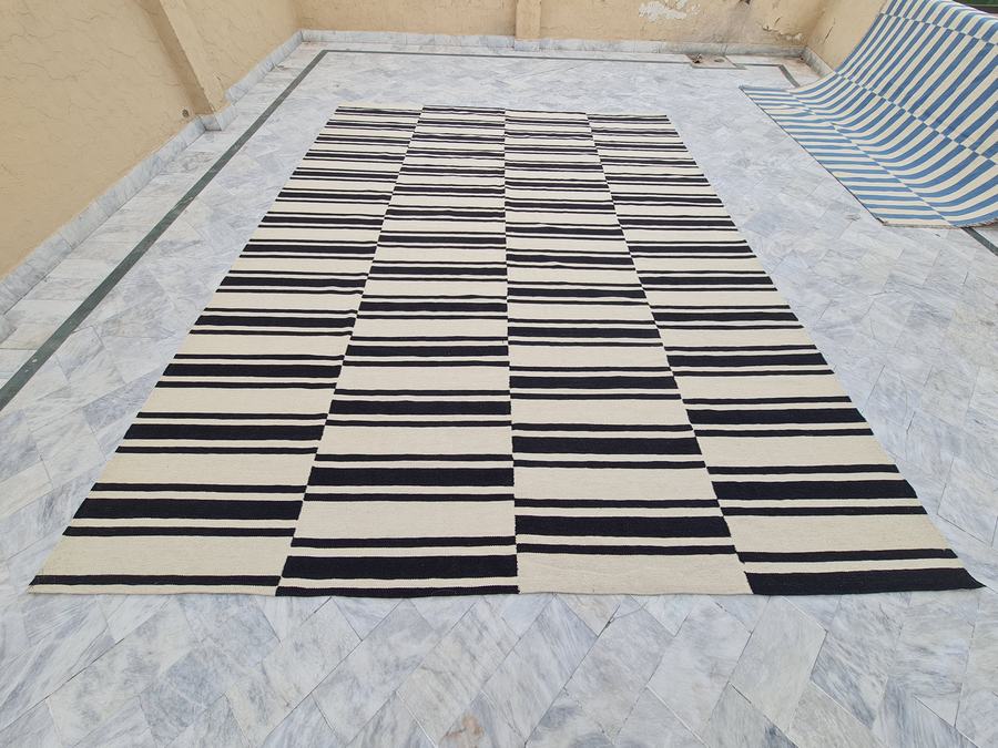 Flatweave kilim rug with a striped design in black and white, woven in our Lahore workshop