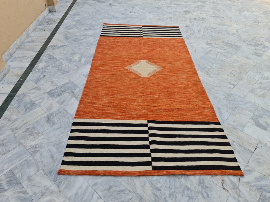 Flatweave kilim rug in orange and black, woven to order