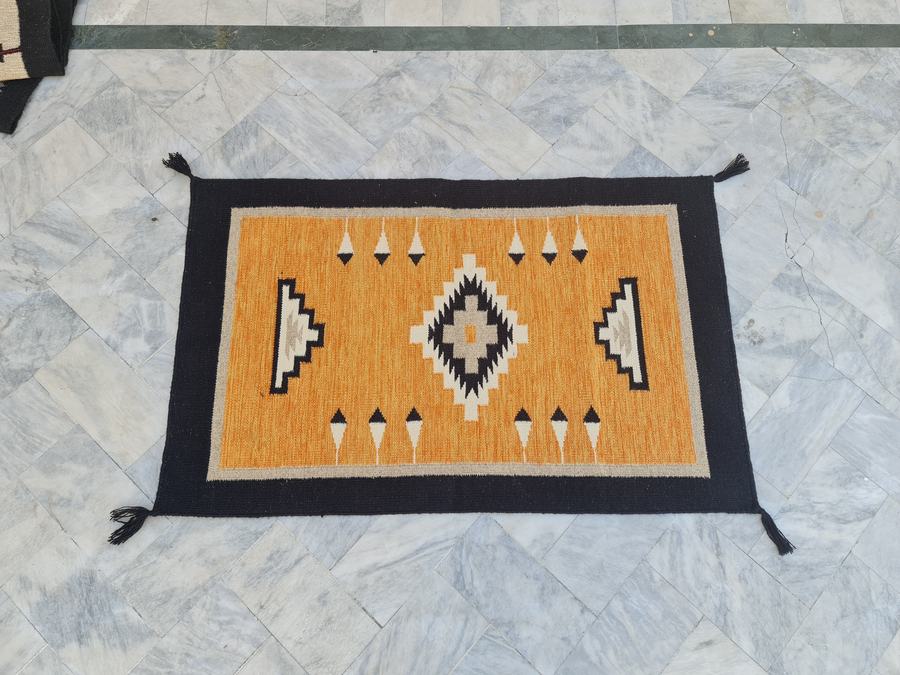 Southwestern flatweave rug in orange and black, woven to order